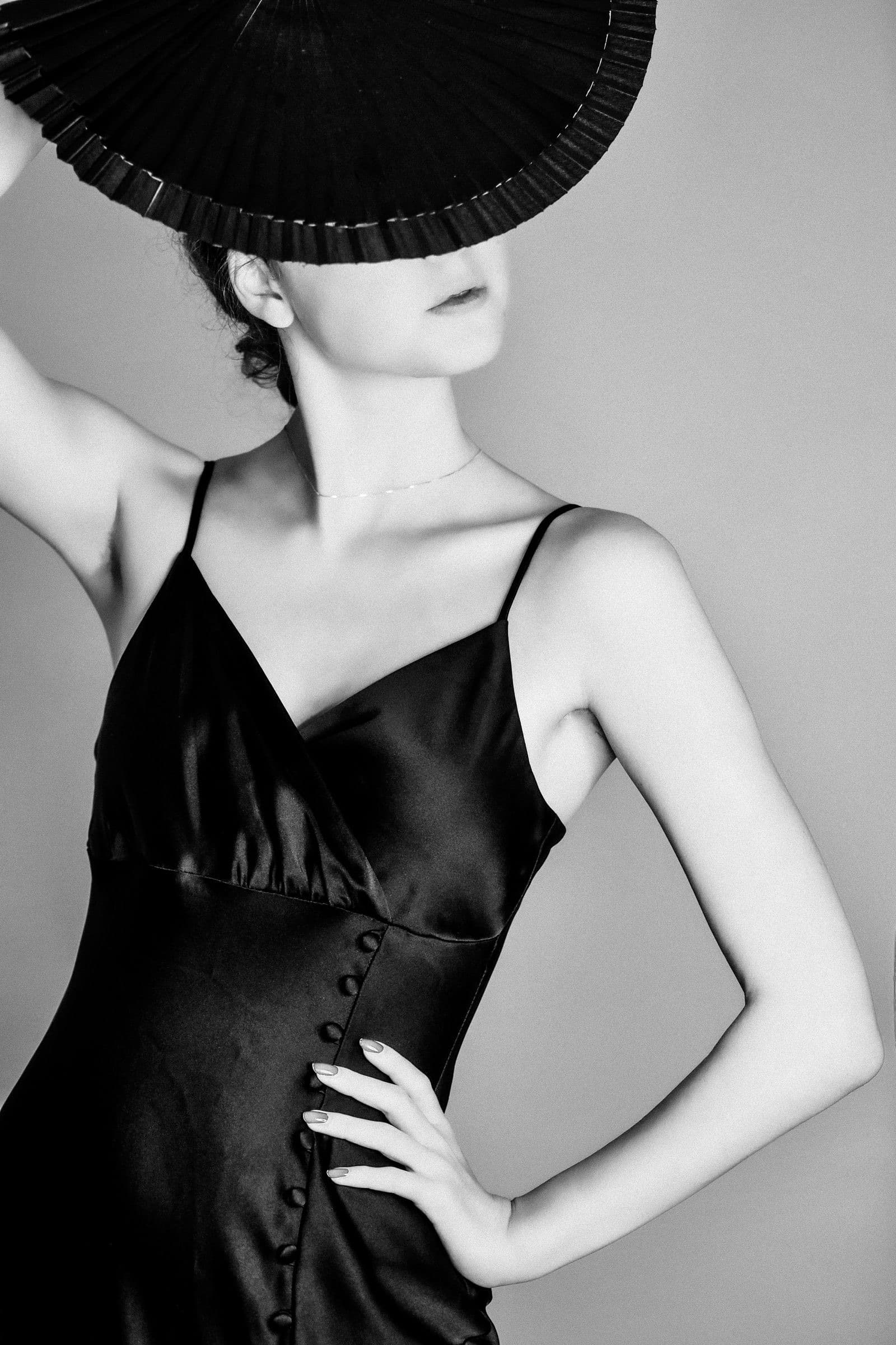 A model in a black silk slip dress