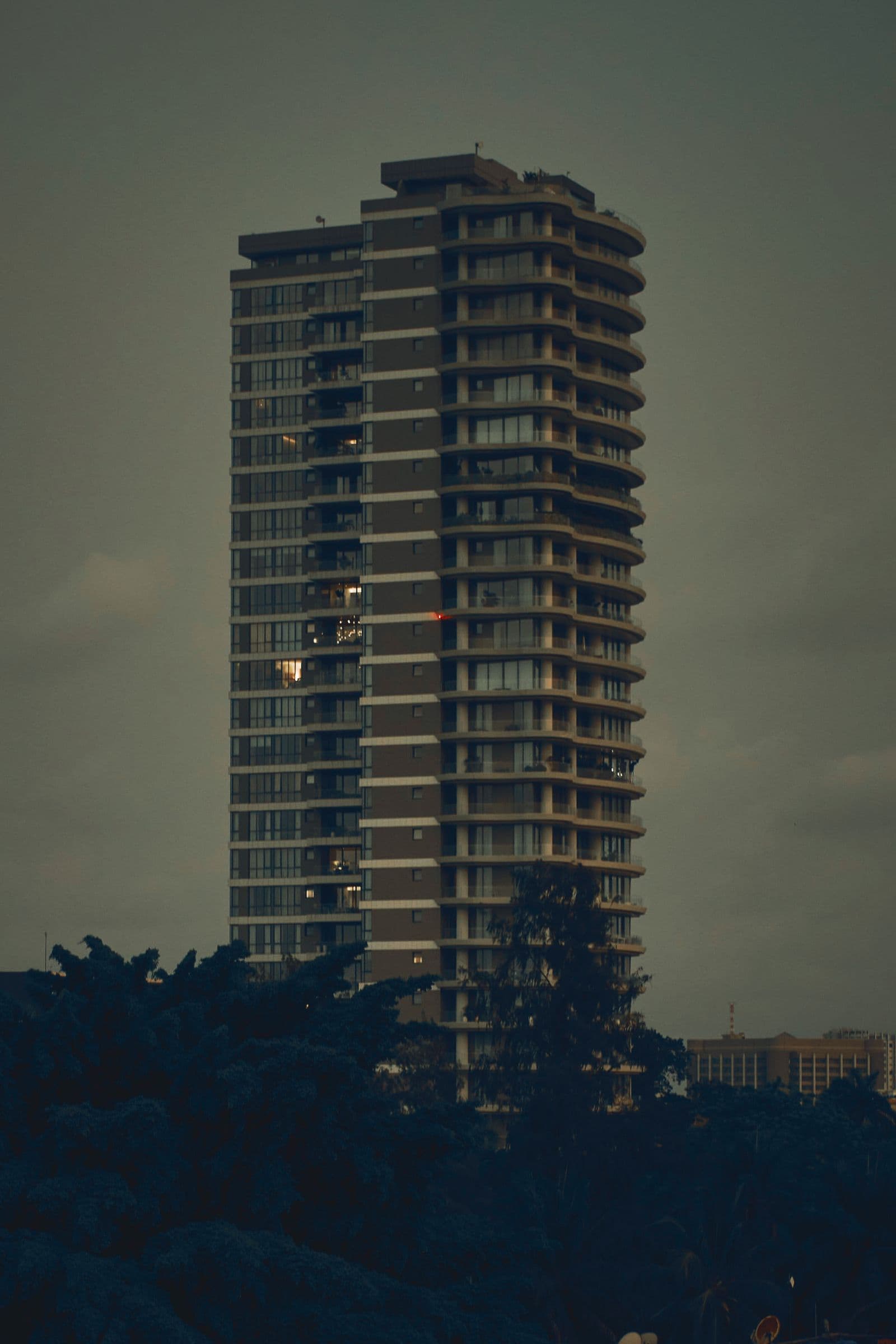 The residences at dusk, framed by trees