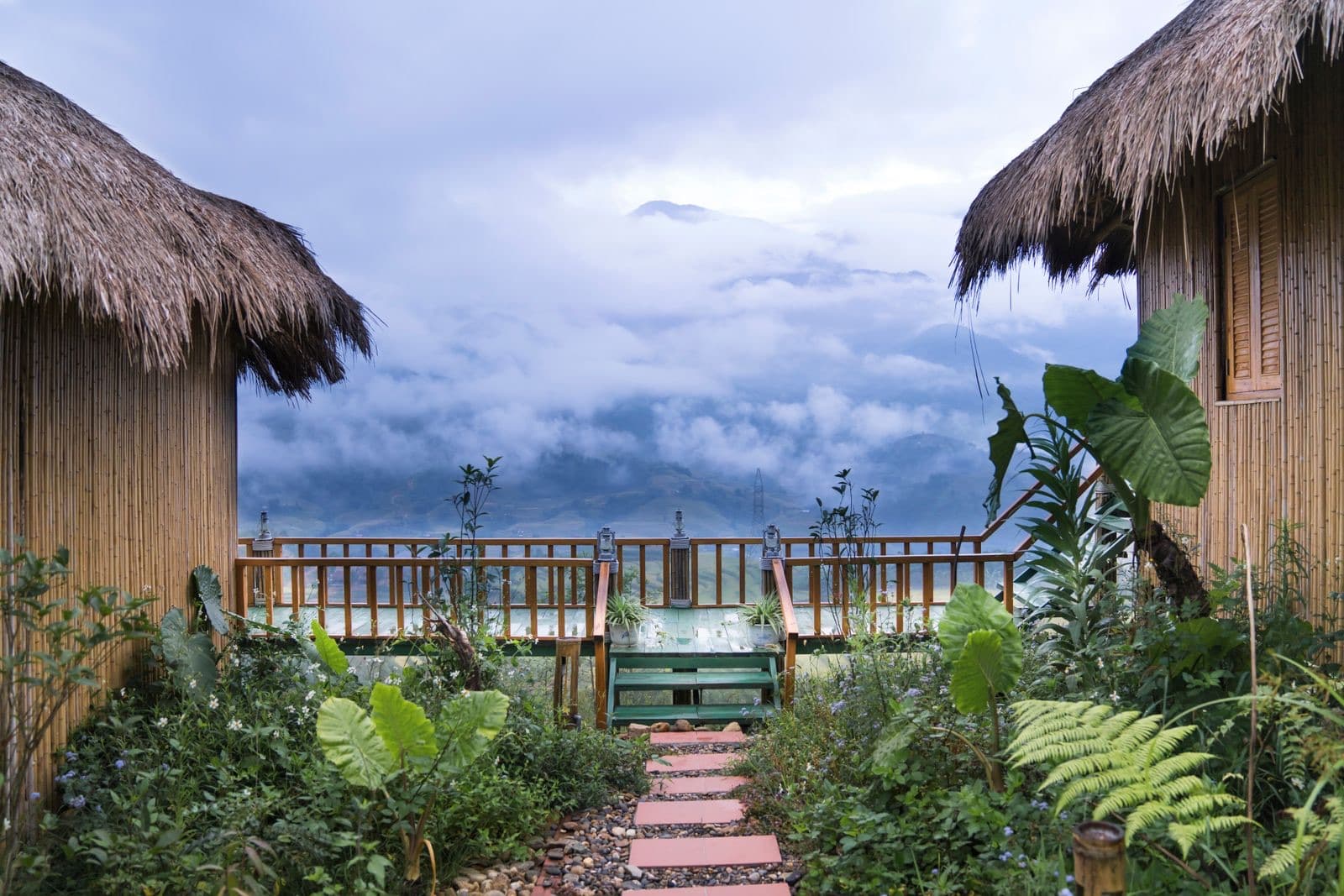 A stone path through a garden toward misty hills