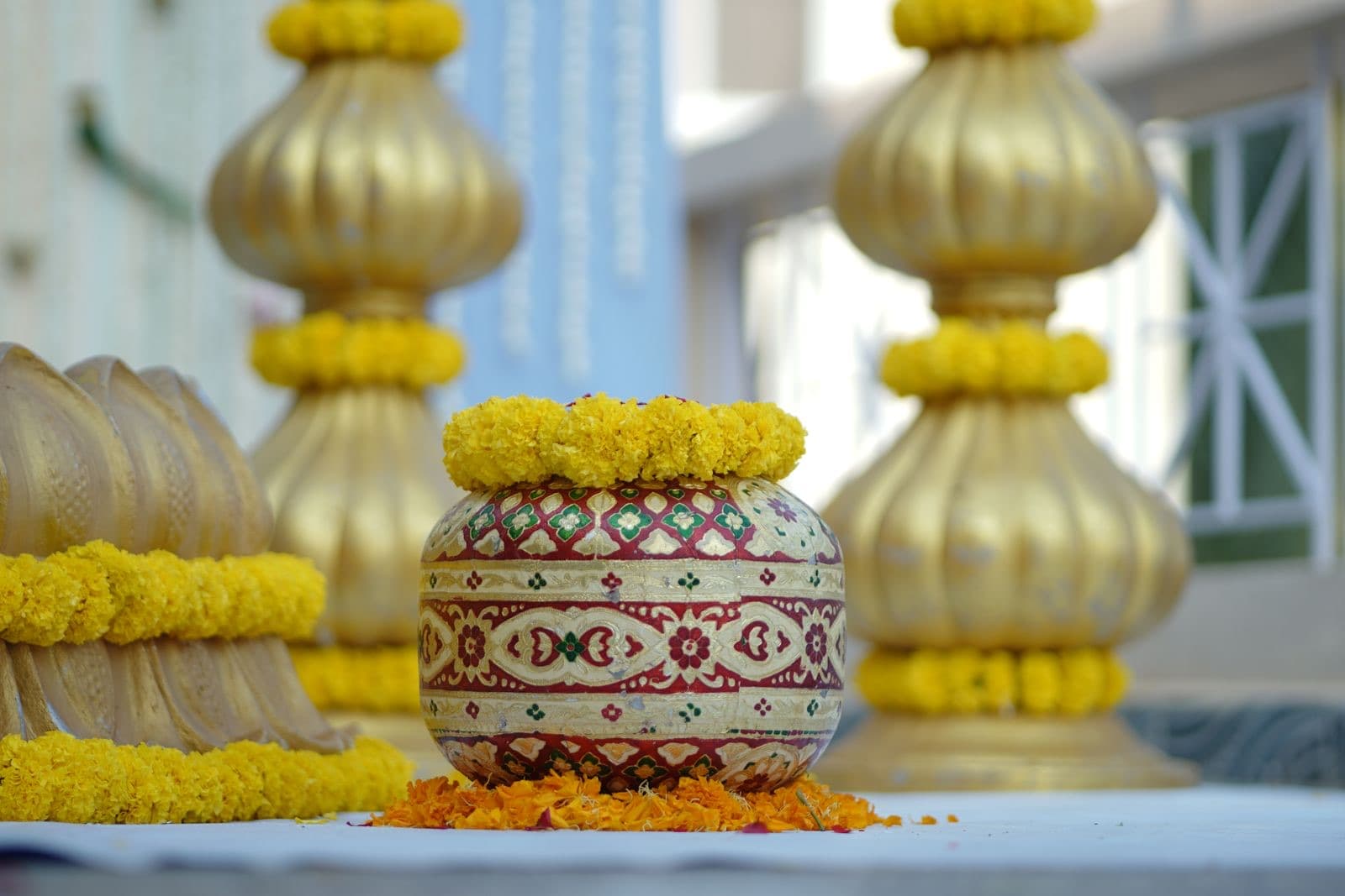 Brass pots and marigold garlands set up for a haldi ceremony